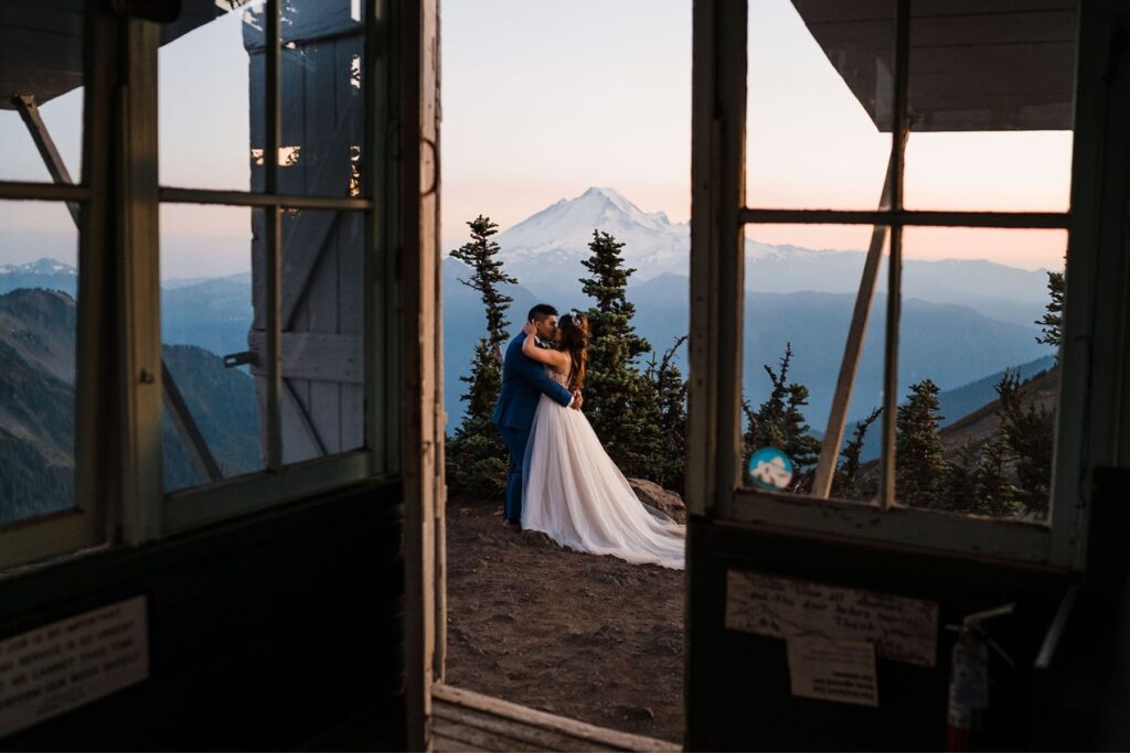 Bride and groom kiss at a fire lookout in the mountains during their elopement in Washington