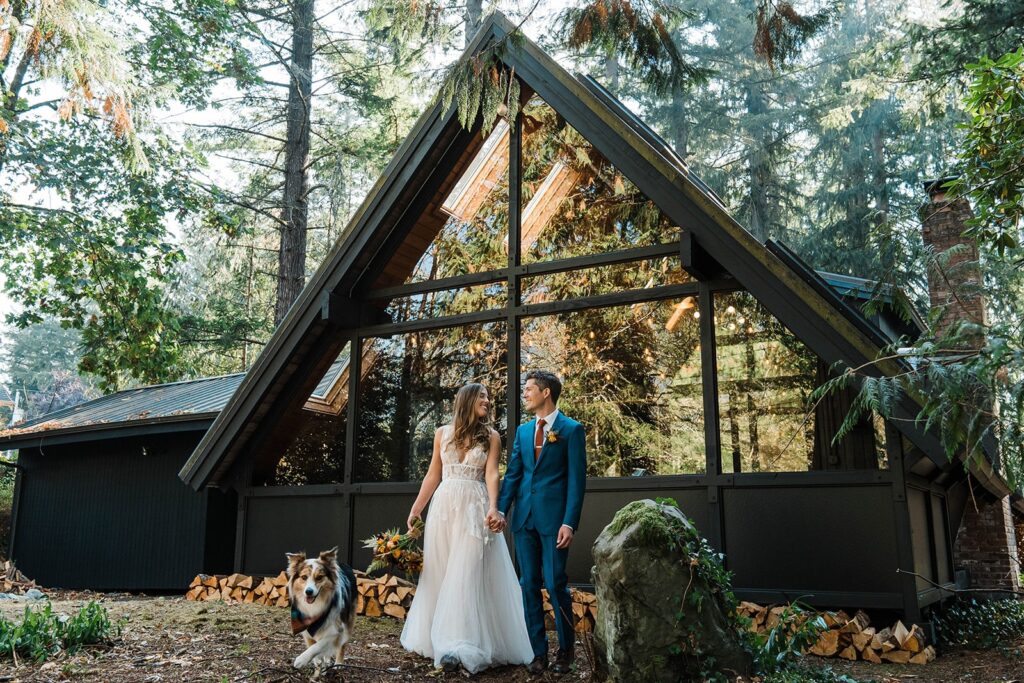 Bride and groom portraits with their pup in front of the Riverbend Retreat cabin in Snoqualmie Pass