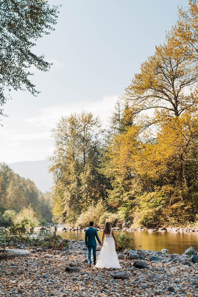 Bride and groom holding hands by the river in Snoqualmie Pass for their Washington elopement
