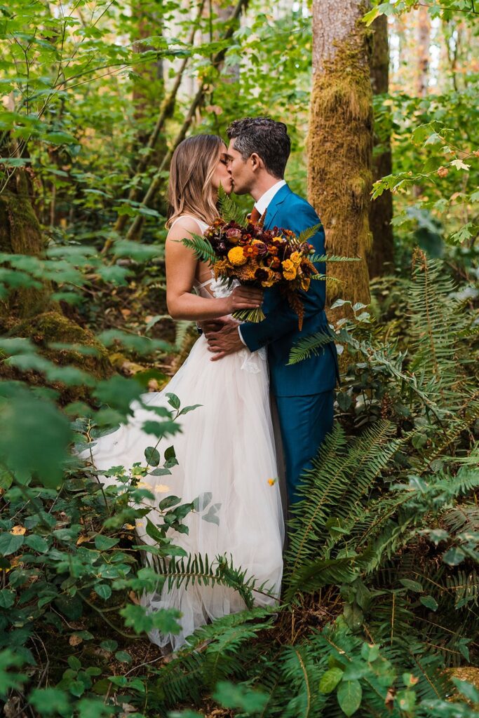 Bride and groom kiss during portrait photos in the forest at Washington elopement in Snoqualmie Pass