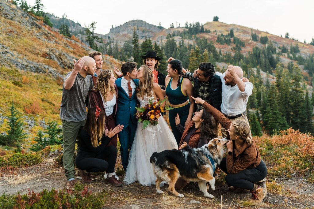 Bride and groom kiss while friends cheer after their elopement ceremony in Snoqualmie Pass