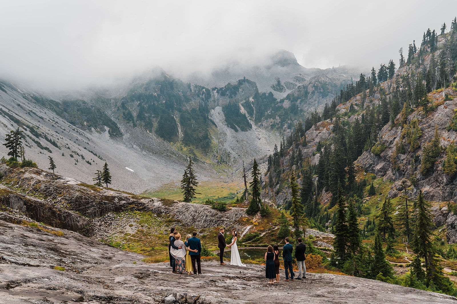 Guests gather on a mountain trail in the North Cascades for a small, intimate wedding ceremony.