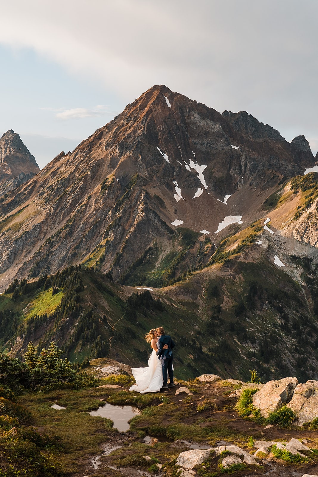 Two brides kiss in the mountains in the North Cascades, one of the most beautiful places to elope in Washington.
