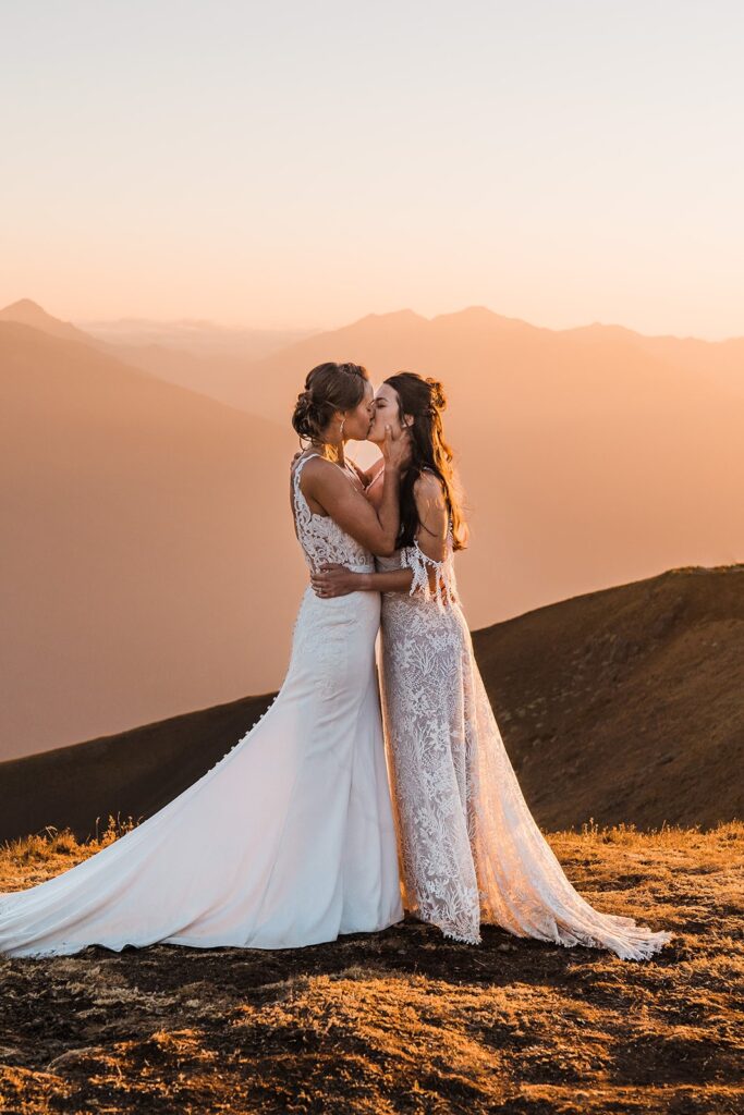 Two brides kiss on a mountaintop in Olympic National Park during their Washington state elopement