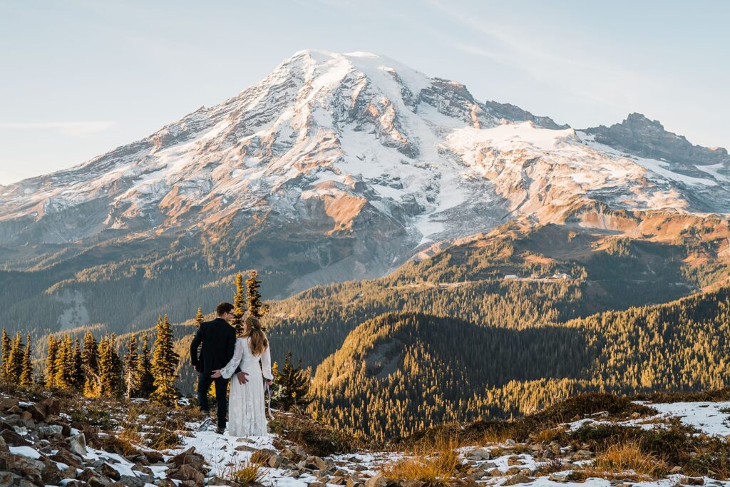 Bride and groom stand in front of a snow-capped Mt Rainier for their Washington state elopement photos