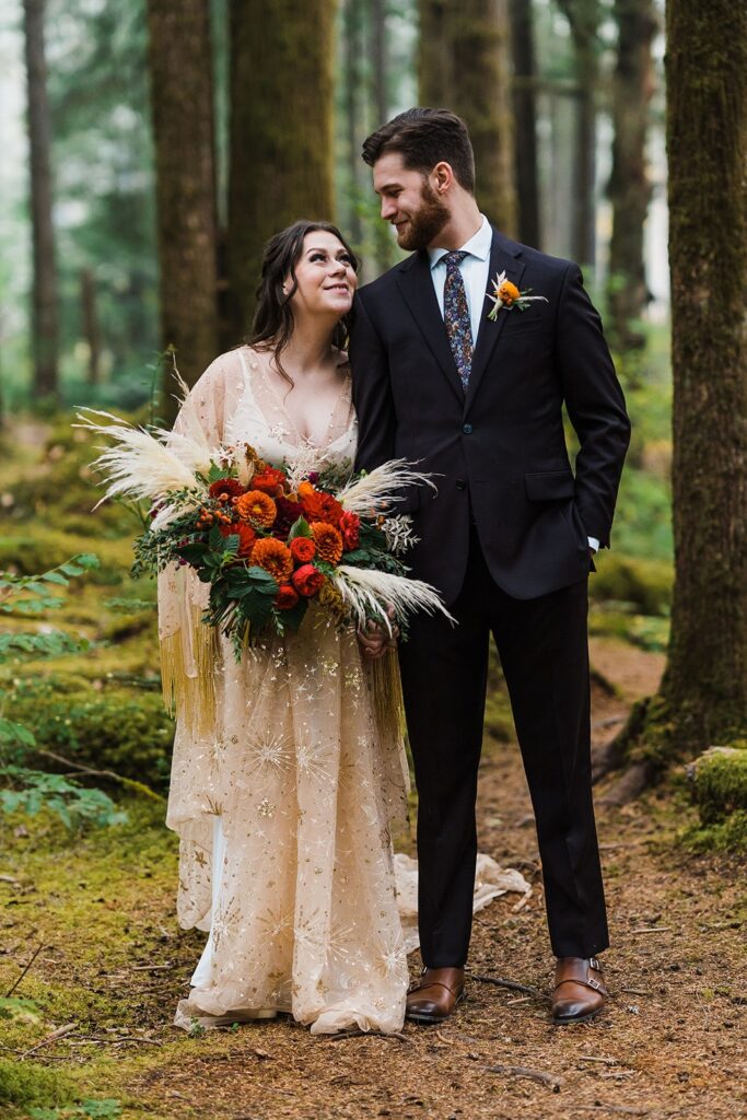 Bride and groom hold hands and gaze into each others eyes during Snoqualmie elopement in the forest