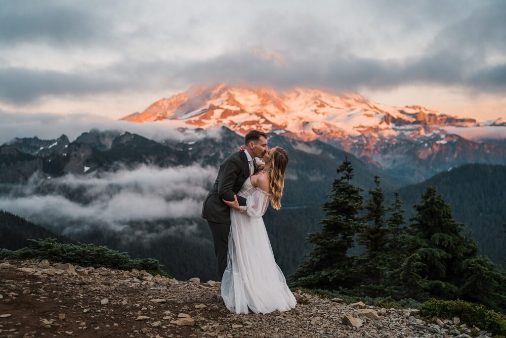 Bride and groom kiss on top of the mountain at their Washington state elopement
