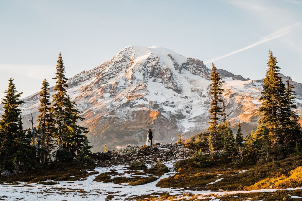 Bride and groom stand in front of Mt Rainier at their Washington state elopement