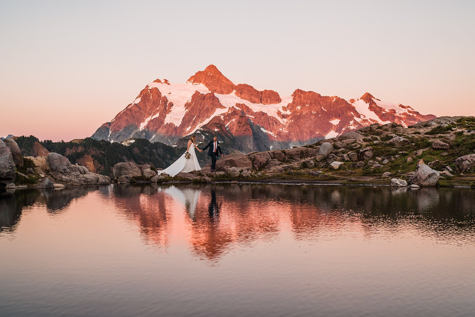 Bride and groom holding hands and walking along Artist Point, one of the best Washington elopement locations in the North Cascades.