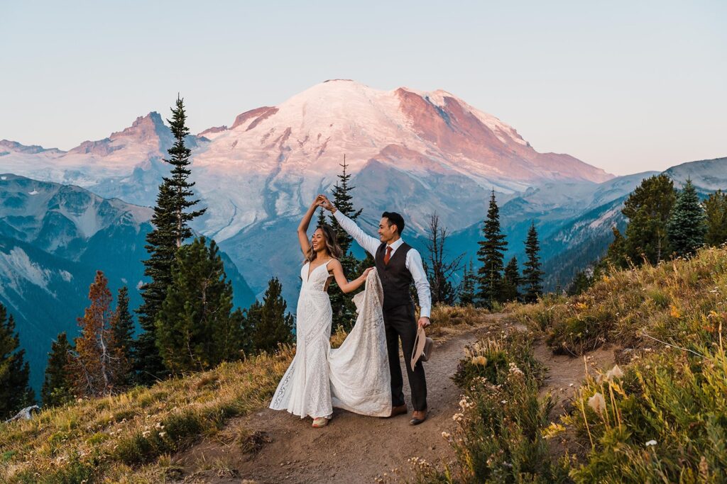 Bride and groom dance at sunset on a mountain trail at Mt Rainier National Park