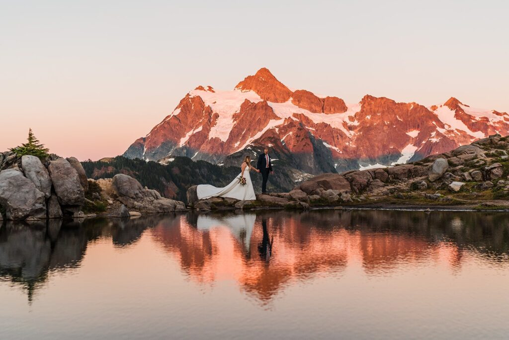 Bride and groom walking across the North Cascades during their sunset mountain elopement