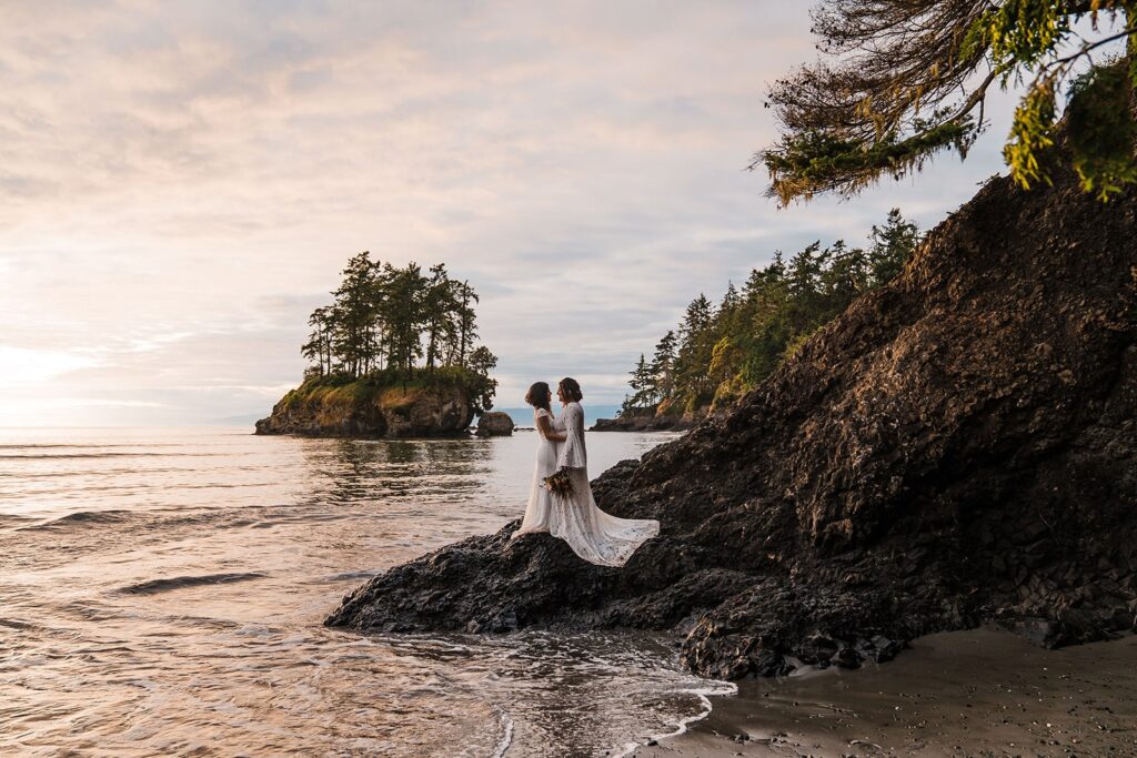 Two brides stand on the side of a hill in Olympic National Park during their mountain elopement