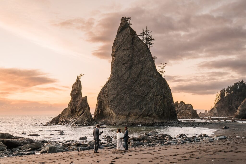 Bride and groom exchange vows on Rialto Beach in front of a jagged sea-stack during their spring elopement in Washington