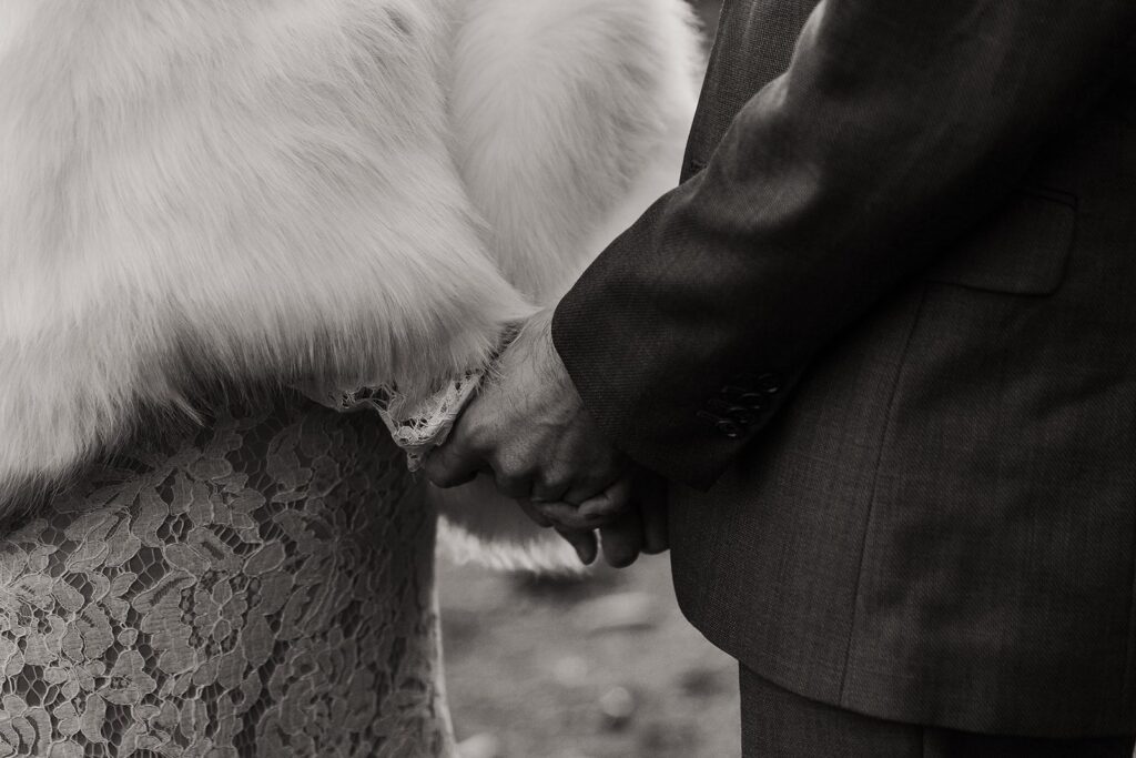 Bride and groom hold hands during their spring elopement ceremony