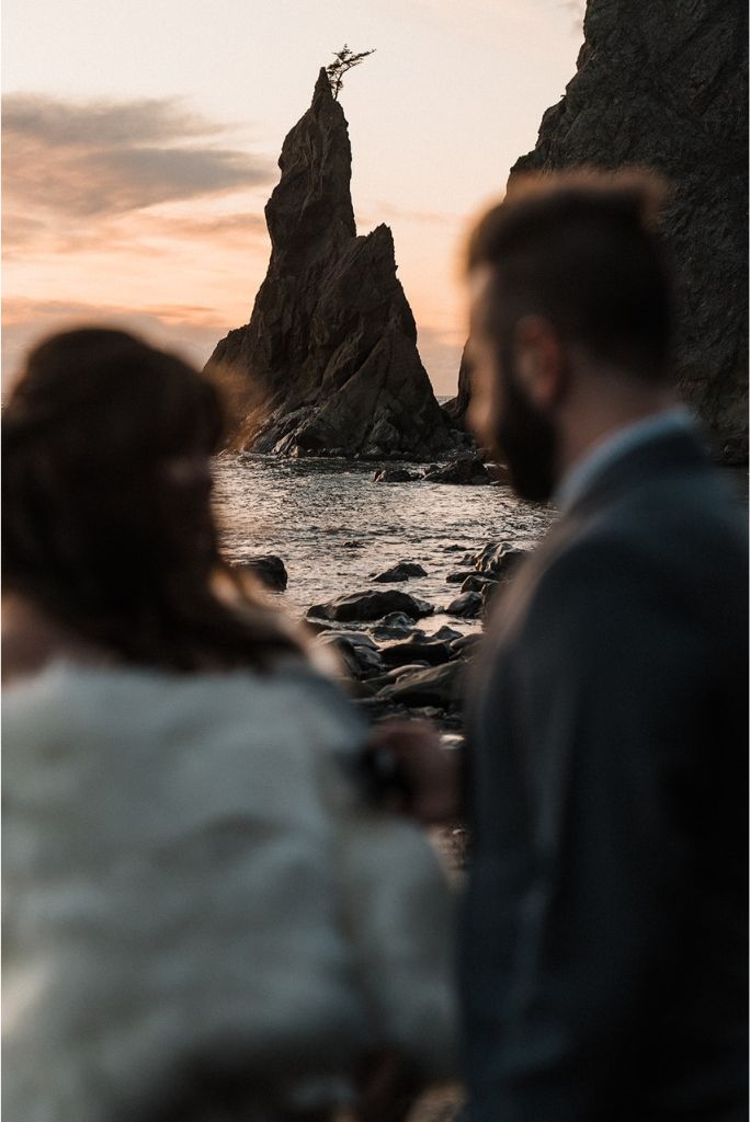 Bride and groom look out at the jagged sea stacks during their spring elopement on the Olympic Peninsula