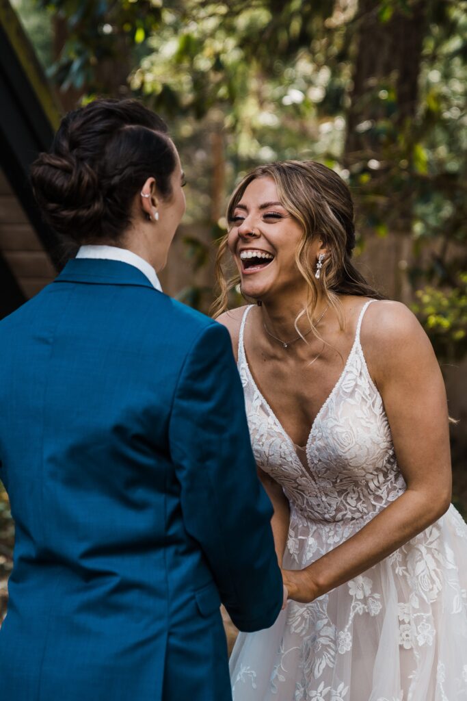 Brides laugh during wedding first look at The Riverbend Retreat cabin