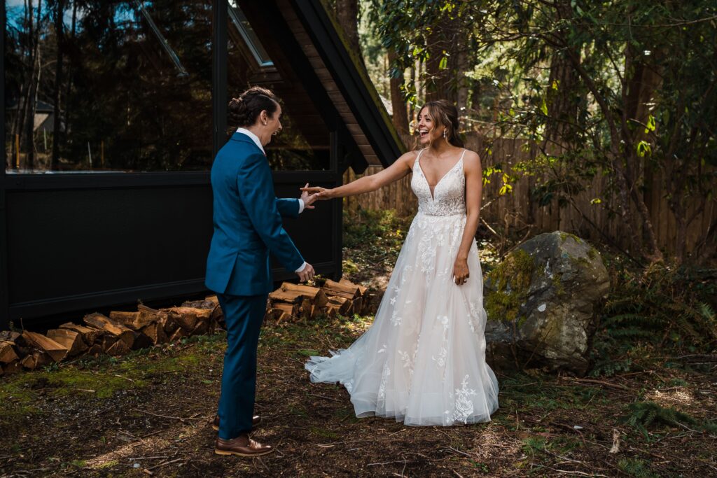 Brides look surprised after turning around for their adventure wedding first look in Snoqualmie