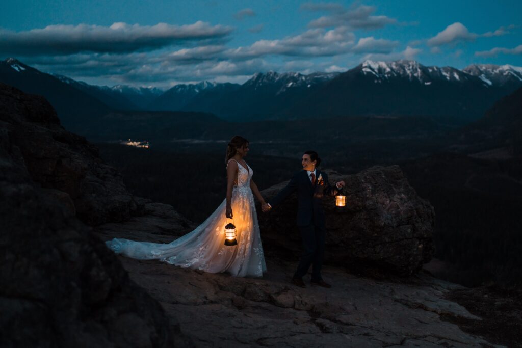 Two brides walk across a mountain at blue hour during their adventure wedding photos in Snoqualmie