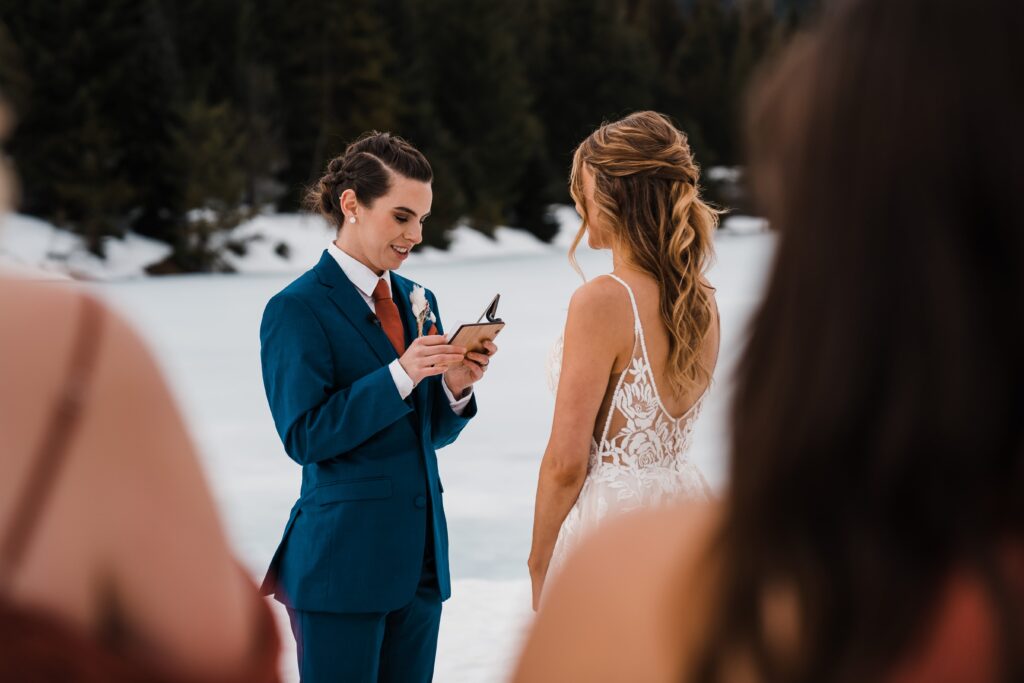 Brides stand in a snowy clearing in Snoqualmie and exchange wedding vows