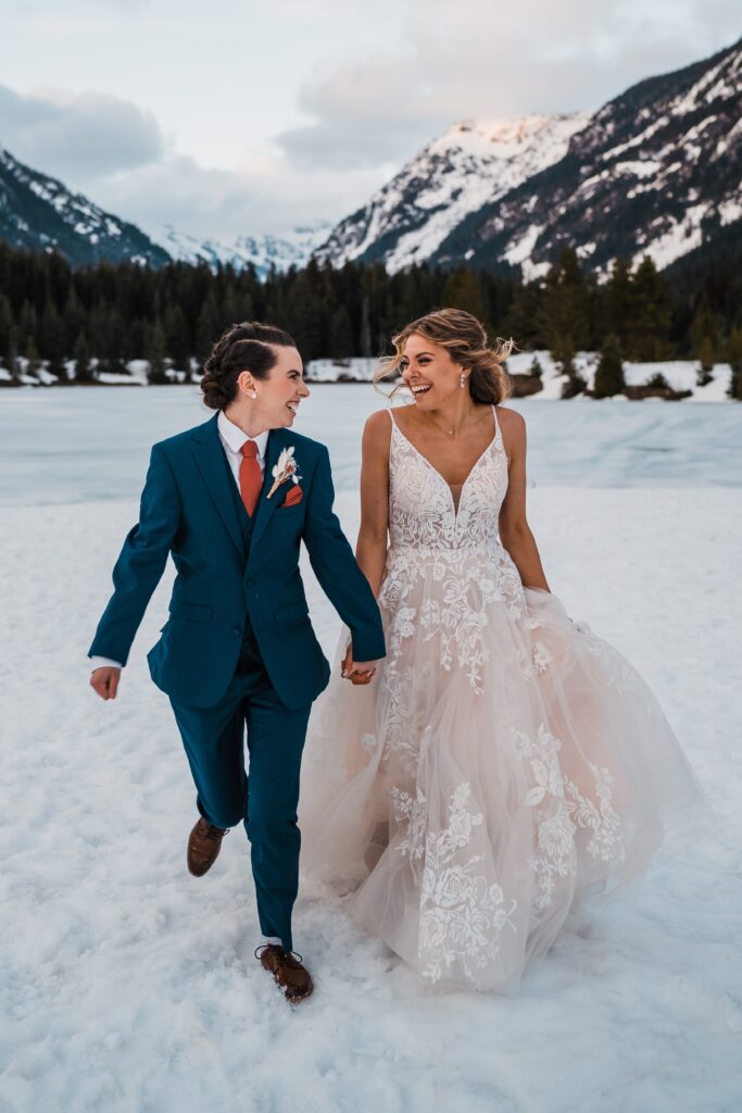 Brides laugh and run while exiting their adventure wedding ceremony in Snoqualmie