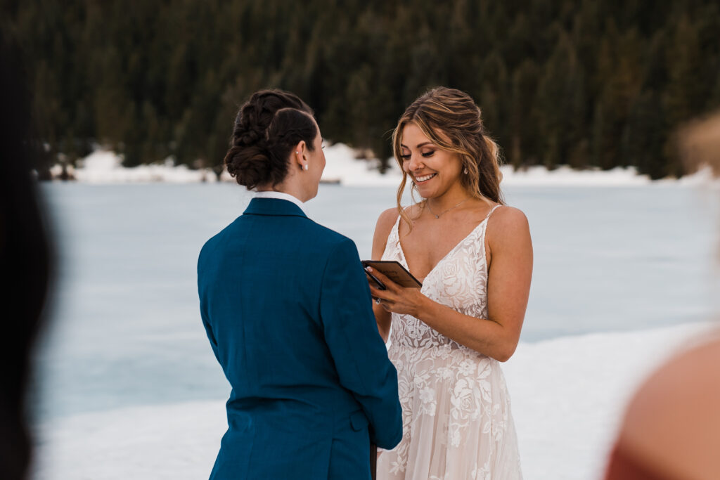 Bride smiles while reading personal vows at adventure wedding in Snoqualmie