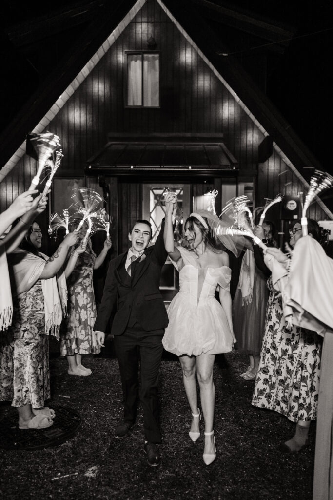 Brides cheer while exiting their adventure wedding celebration