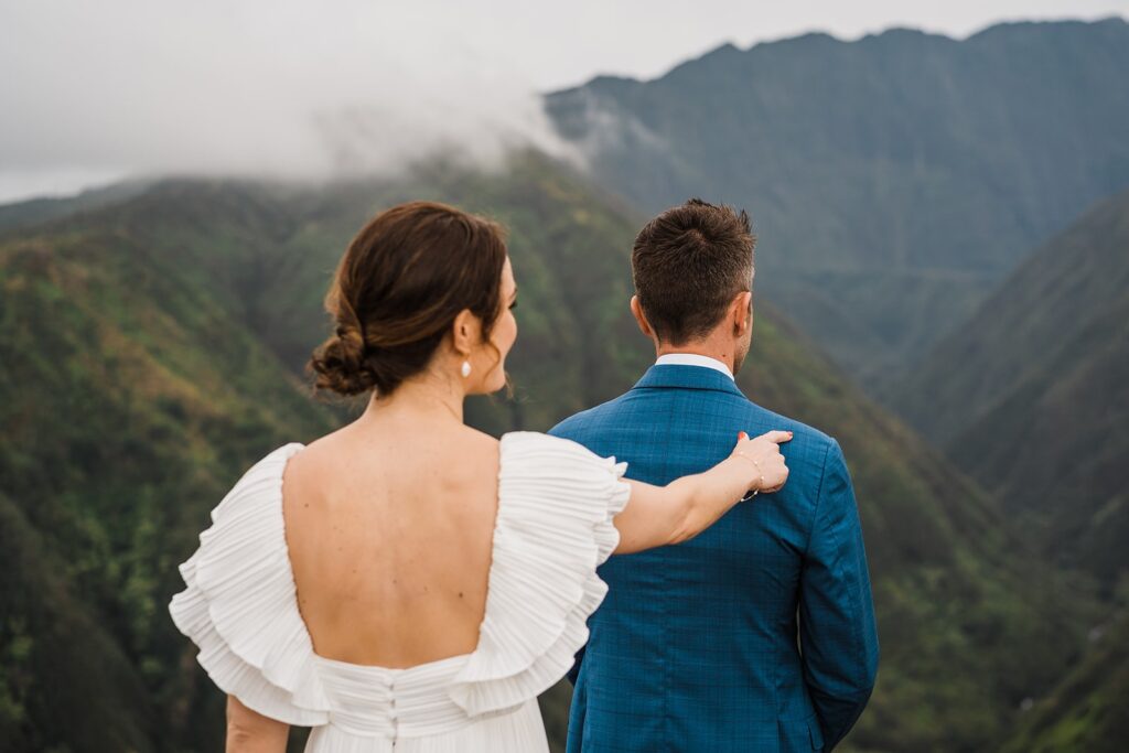 Bride taps groom on the should during their first look at their Maui elopement in the mountains