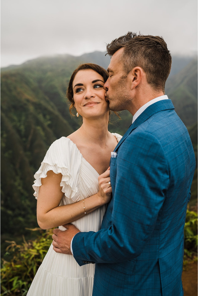 Groom kisses bride on the cheek during their elopement in Hawaii