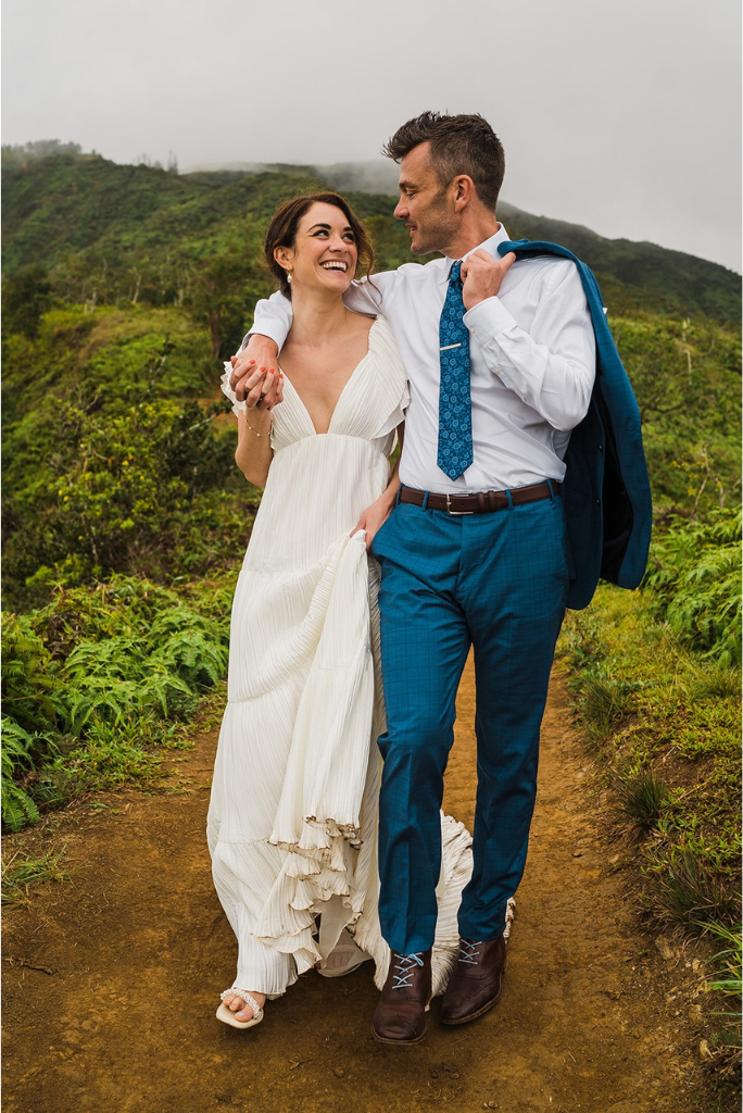 Bride and groom laugh and walk through the mountains during their Maui elopement