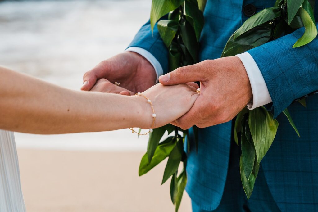 Bride and groom hold hands during their Maui elopement ceremony on the beach