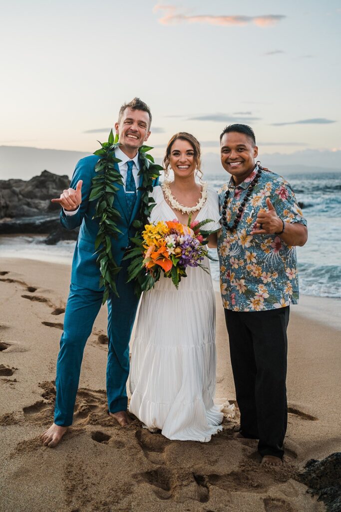 Bride and groom couple photo with officiant after their traditional Hawaiian elopement ceremony on the beach in Maui