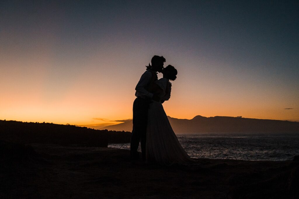 Bride and groom kiss during blue hour at their Hawaii elopement 