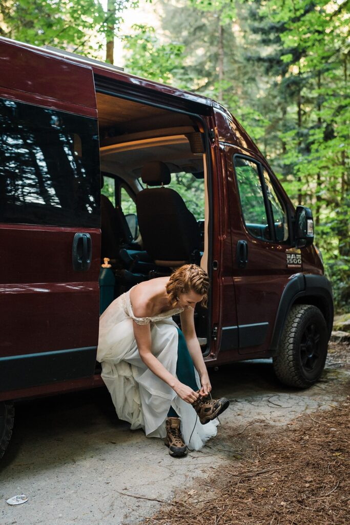 Bride lacing up hiking boots in her camper van at Jedediah Smith Redwoods State Park