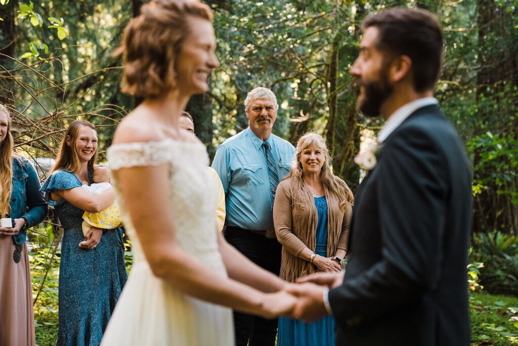 Bride and groom hold hands during their redwoods elopement ceremony in California