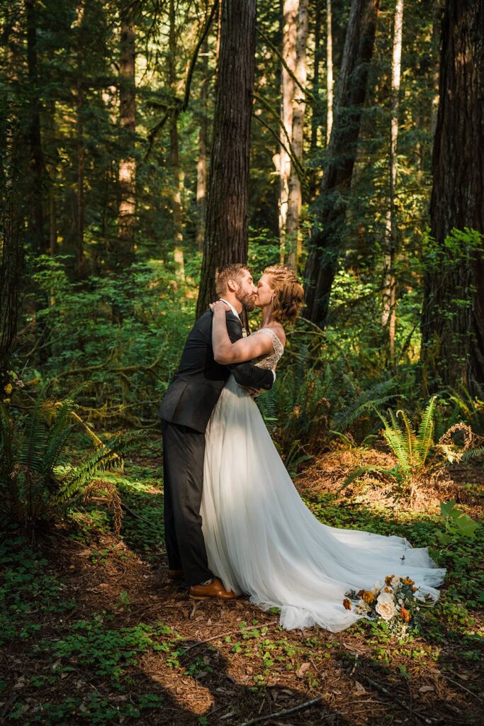 Bride and groom kiss during their redwoods elopement ceremony at Jedediah Smith Redwoods State Park