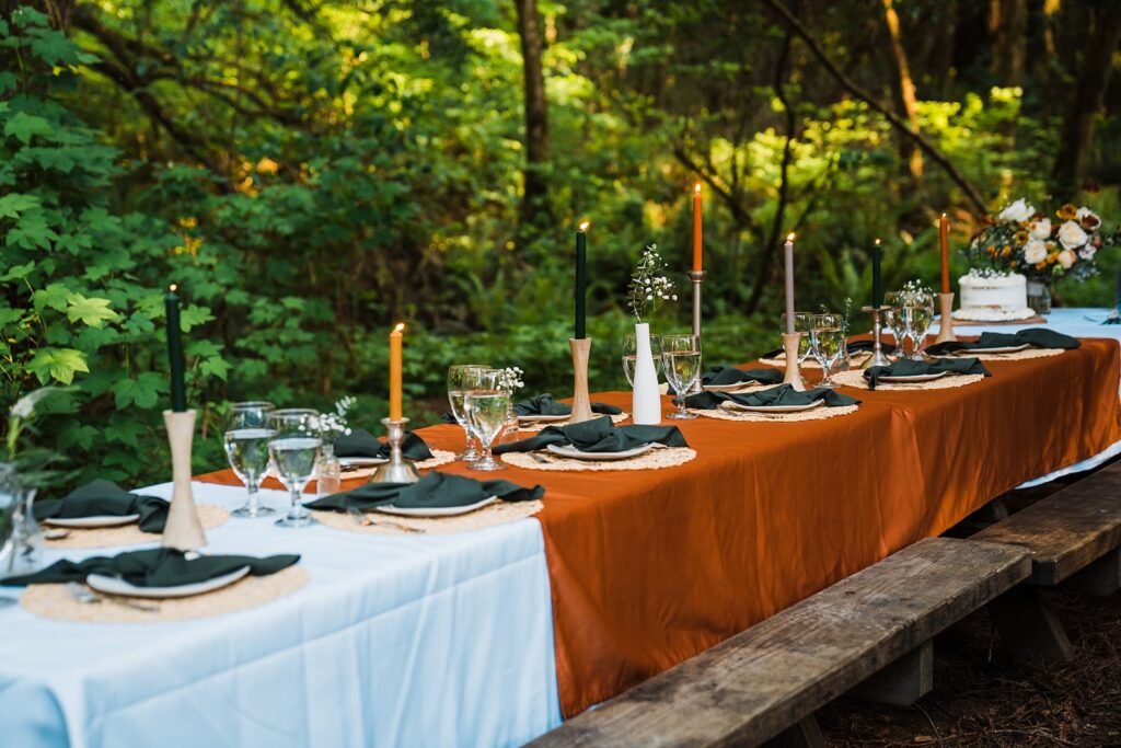 Burnt orange wedding reception table in the forest