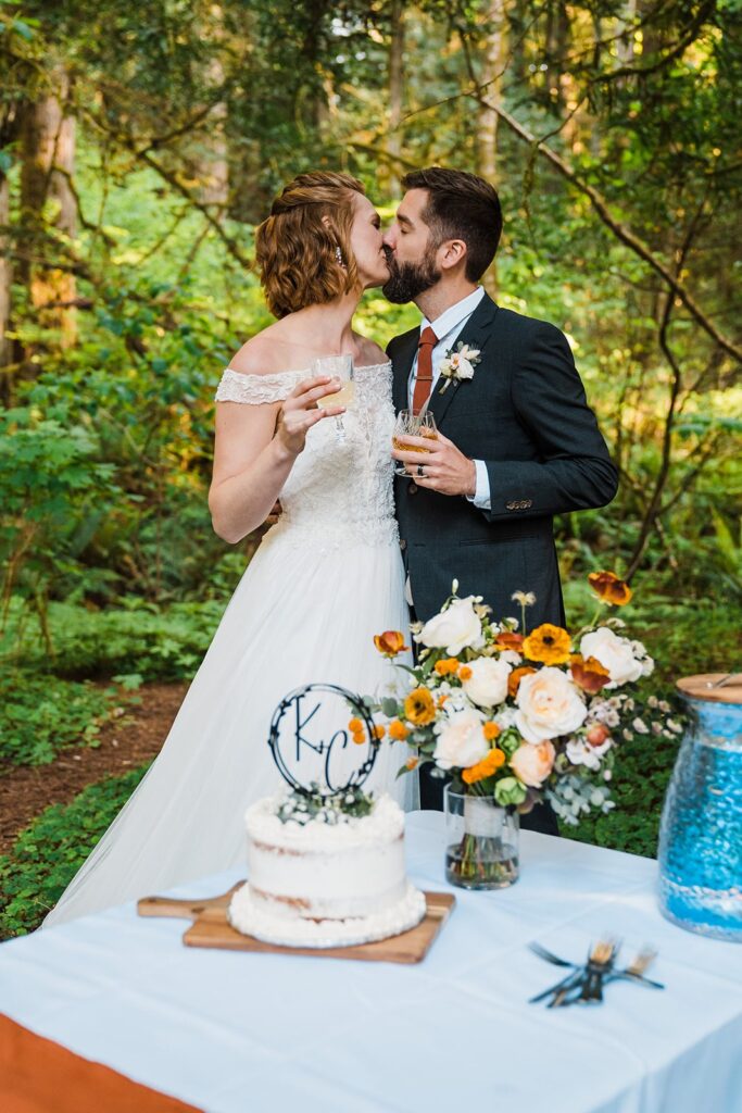 Bride and groom kiss during their wedding reception in the forest