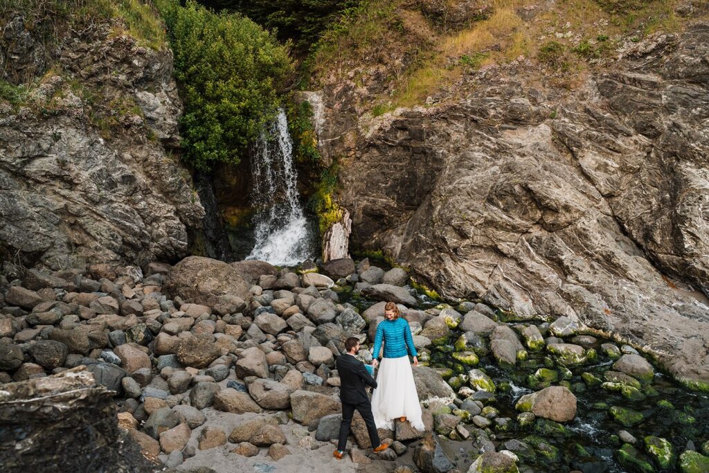 Bride and groom hike down the coast for sunset elopement photos in Oregon