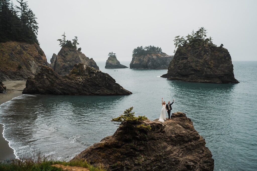 Bride and groom cheer during their beach elopement photo session in Oregon