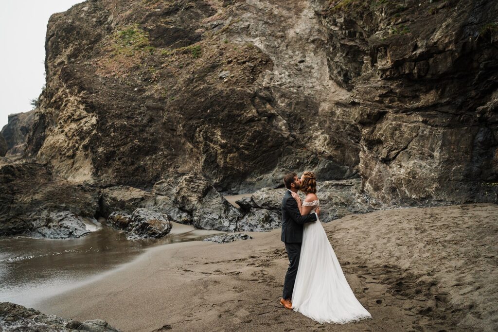 Bride and groom kiss on the beach at their Oregon Coast elopement session
