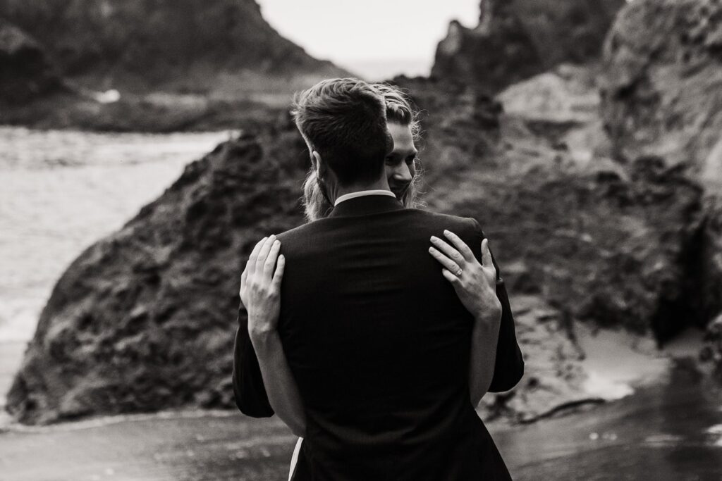 Bride and groom hug on the beach during their Oregon Coast sunset elopement photos