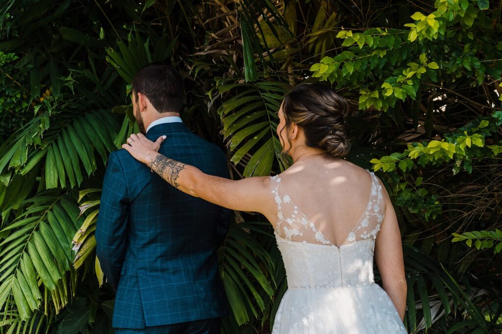 Bride tapping groom on the shoulder during first look in Kauai