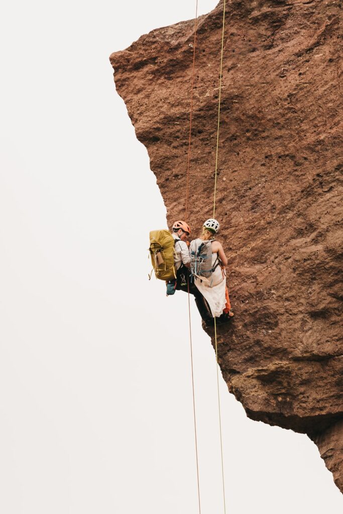 Couple repel up a rock during their climbing elopement at Smith Rock State Park