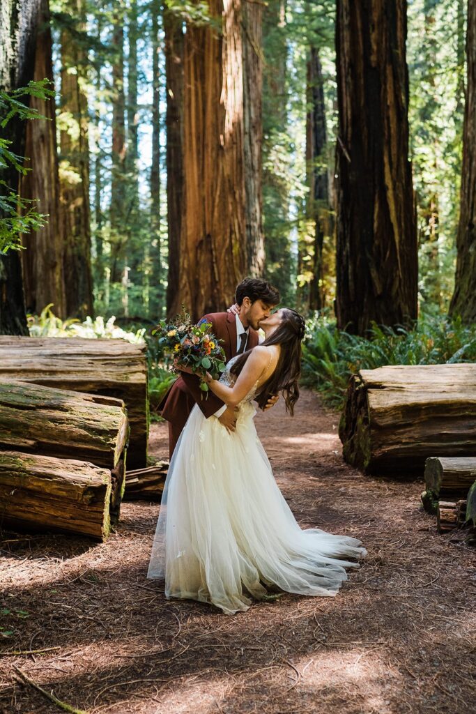Bride and groom dip for a kiss in the forest during their Redwoods elopement in Oregon