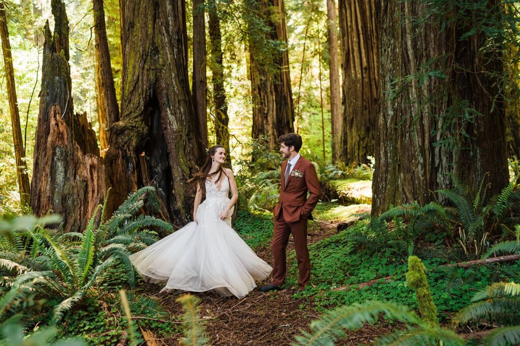 Bride twirls in white wedding gown during redwoods elopement photos on the Oregon Coast