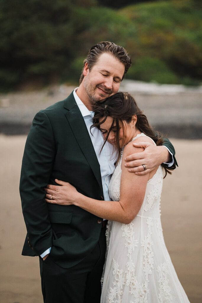 Bride and groom hug on the beach during their Oregon Coast elopement