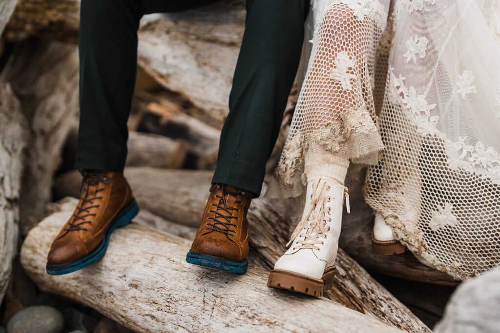Bride and groom wearing white and brown leather hiking boots on the beach during their sunrise Oregon Coast elopement