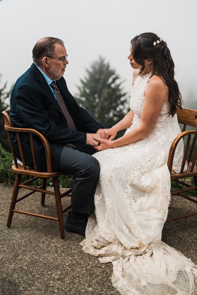 Bride hold hands with father during first look moment on the Oregon Coast 
