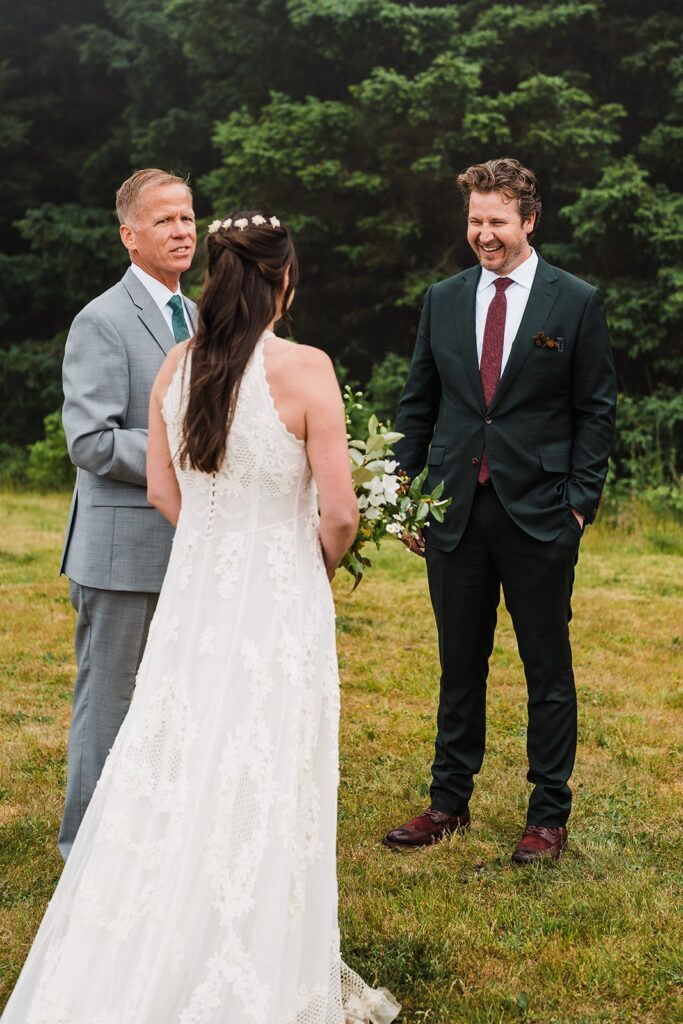 Groom laughs during outdoor elopement ceremony on the Oregon Coast