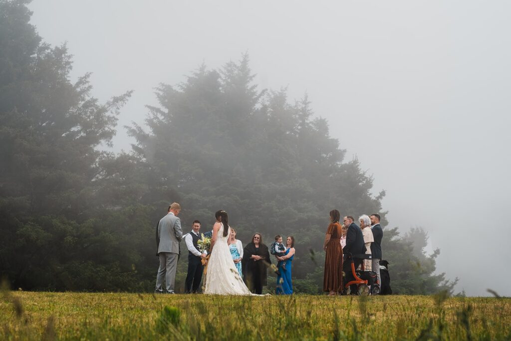 Guests watch as bride and groom exchange vows during their elopement on the Oregon Coast 